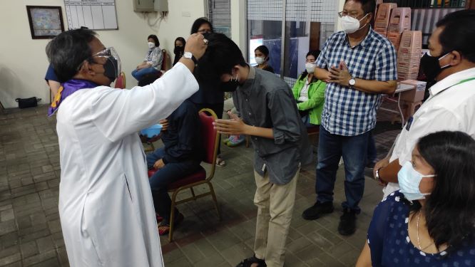 Prodiakon menaburkan abu diatas kepala dengan sendok--